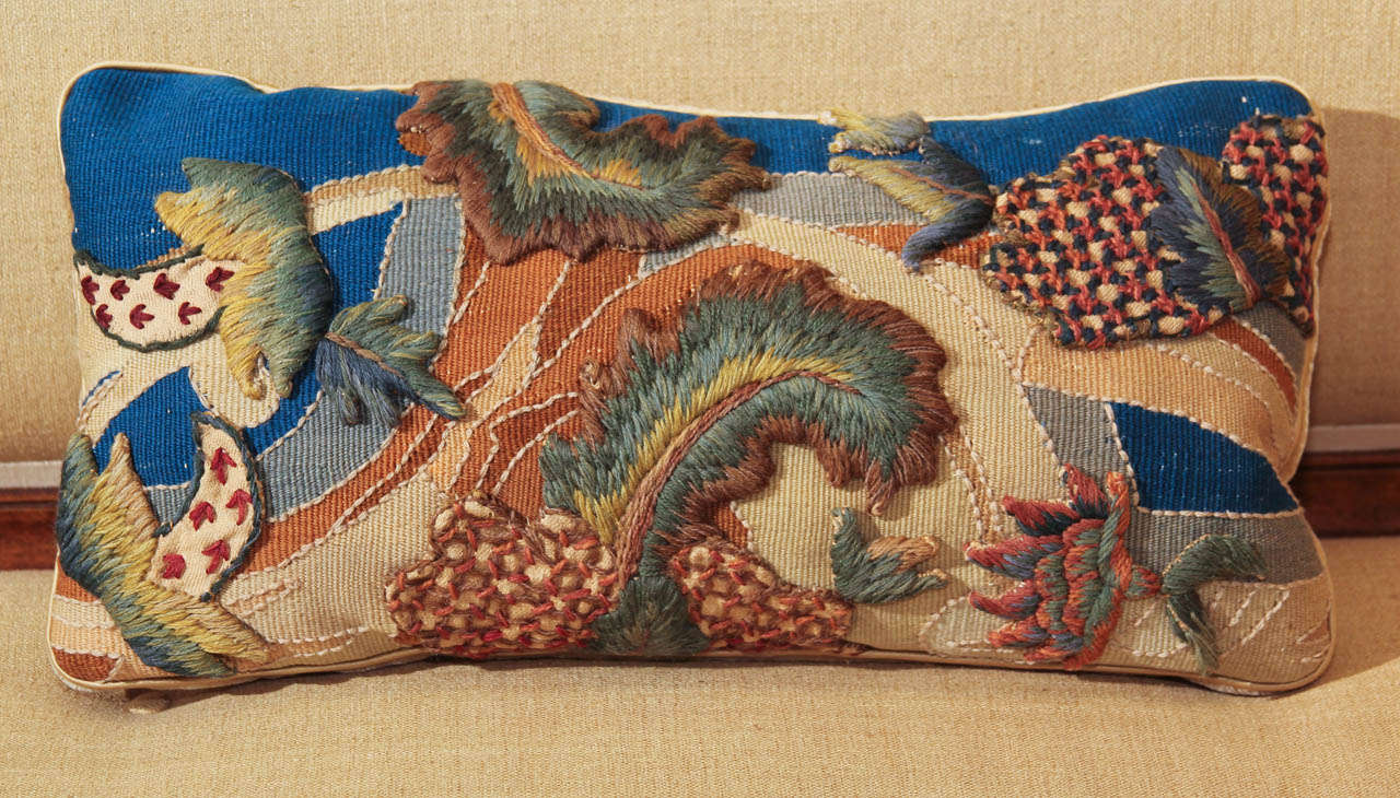 A pillow constructed from a 19th century aubusson fragment appliquéd with needlework fragments