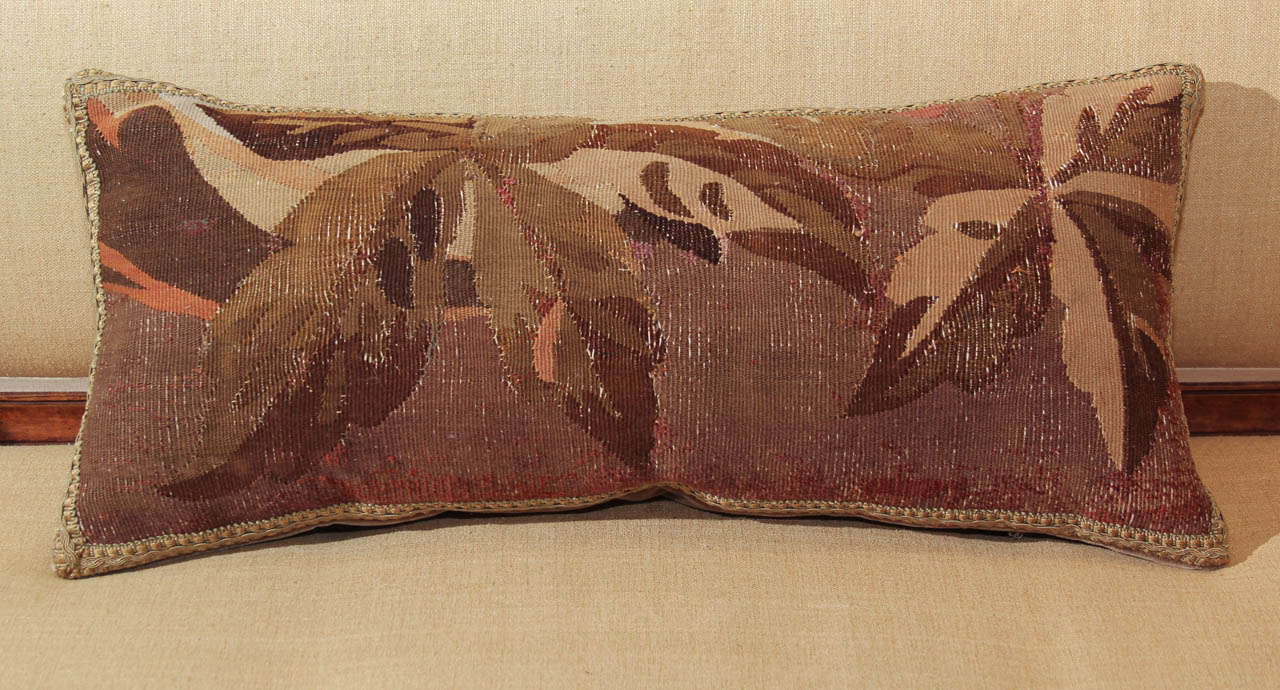 A pillow made from a 19th century French Aubusson carpet fragment. Feather down fill and backed with mohair.
