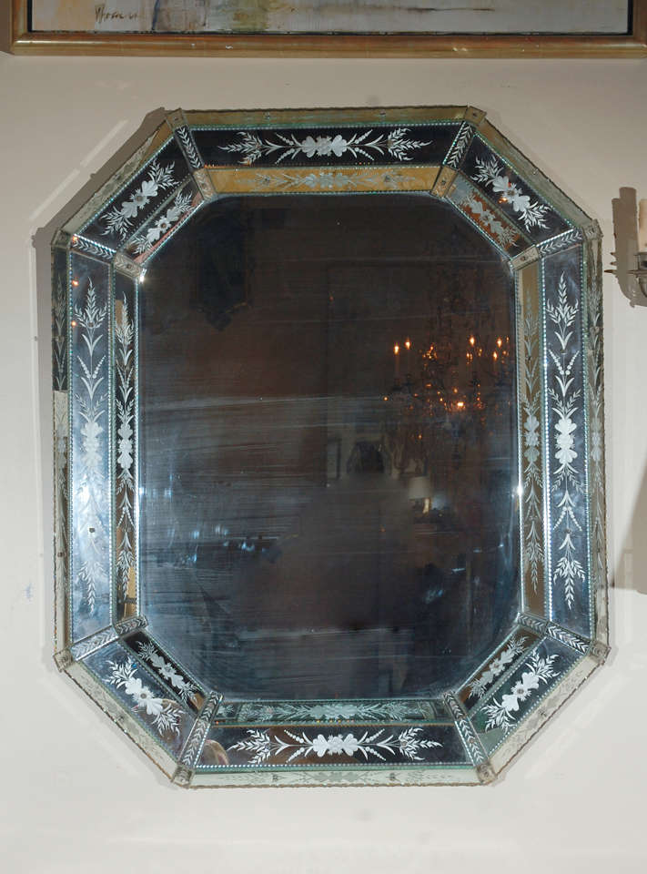 A large, glamorous, beveled, octagonal, Venetian mirror with fine, etched floral details throughout.
