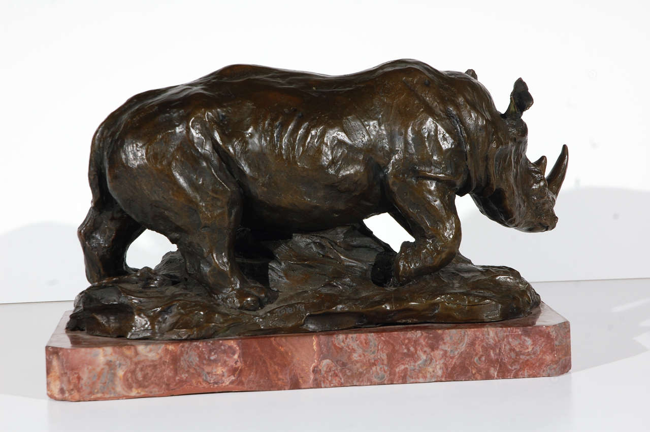 Hand-cast, bronze sculpture of a Rhinoceros on a rouge marble base by Portuguese born, French sculptor Charles Correia (1930-1988).