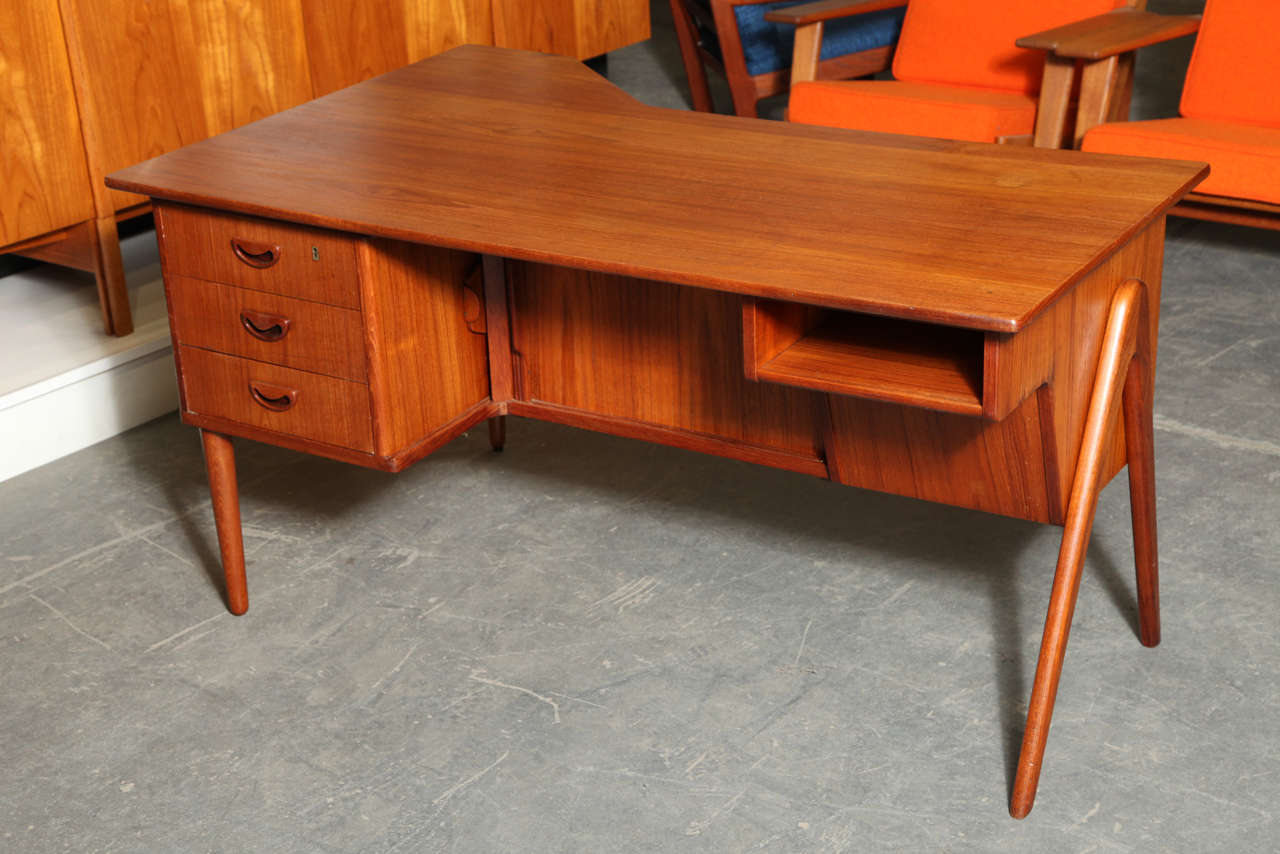 Atomic Era Style Teak Partner's Desk.  Features 2-Sided Tambour Bar Cabinet, semicircular drawers with steambent pulls, and A-shaped legs.

Located at ABC Home 888 Broadway 2nd Floor, New York.