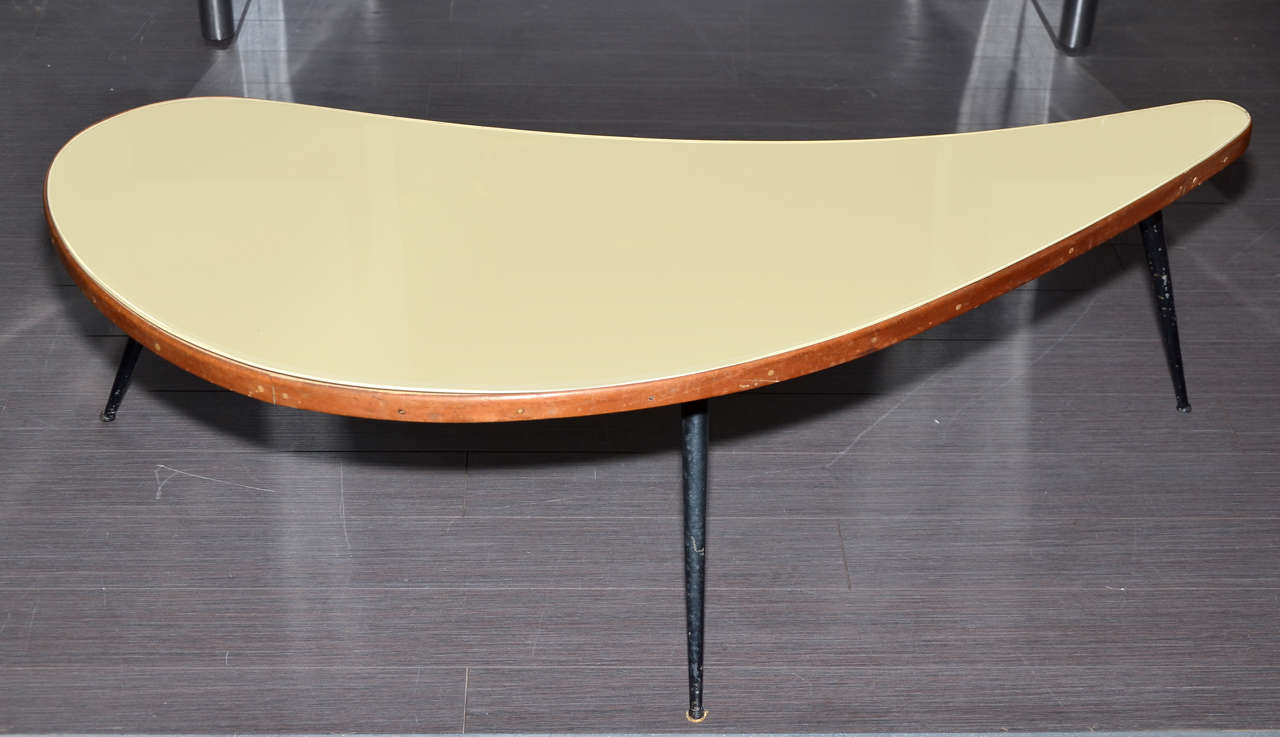 1950s Italian coffee table supported by three black metal legs and with a top surface in the original glass painted ivory.