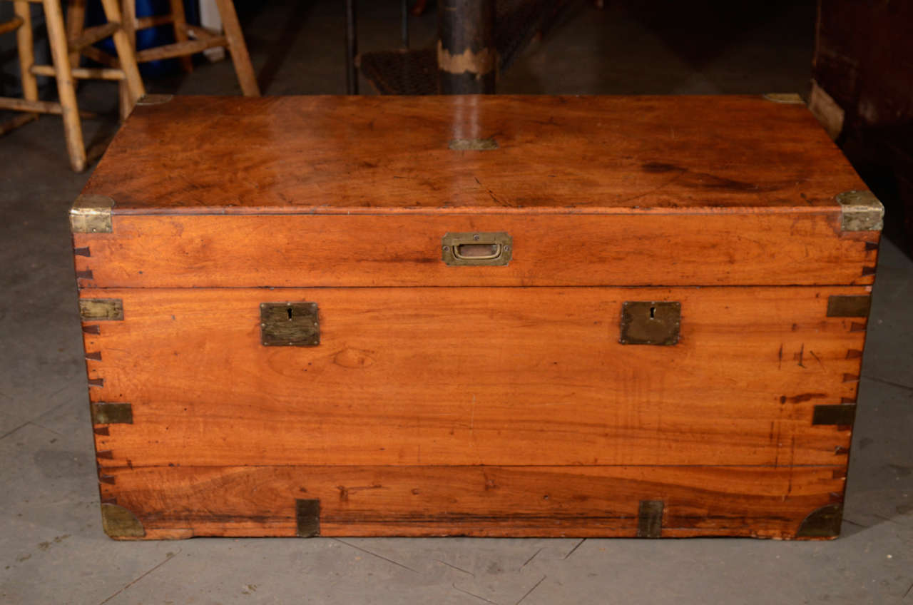 Of rectangular form with brass-plated edges, the top with a rectangular plaque on top of a hinged lid with a recessed handle, enclosing an open interior. Handles on either side.

This China trade chest from the 19th century is made from aromatic