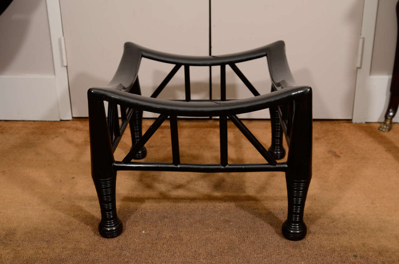 An Ebonized 'Thebes' Stool, c. 1890-1920. Possibly made for Liberty & Co., probably by the firm of William Birch or B. North & Sons, both of High Wycombe, Buckinghamshire. The design copied from an ancient Egyptian original. This stool is based on