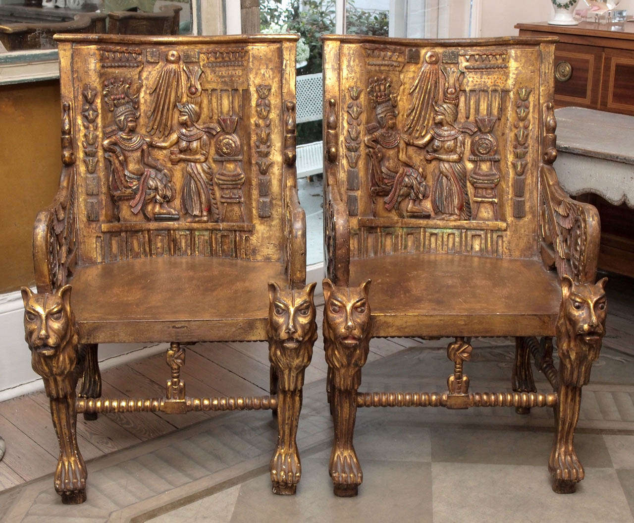 These showstopping Art Deco era chairs were inspired by the throne chairs found in King Tutankhamun's tomb. Giltwood with detailed carving.