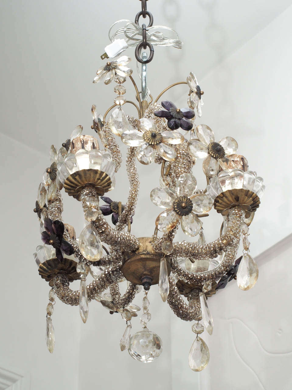 Delicate chandeliers with beaded arms and crystal flowers.
