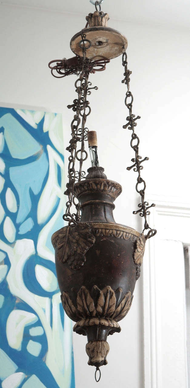 Small painted wood chandelier with carved grape and grape leaf details and a decorative chain.