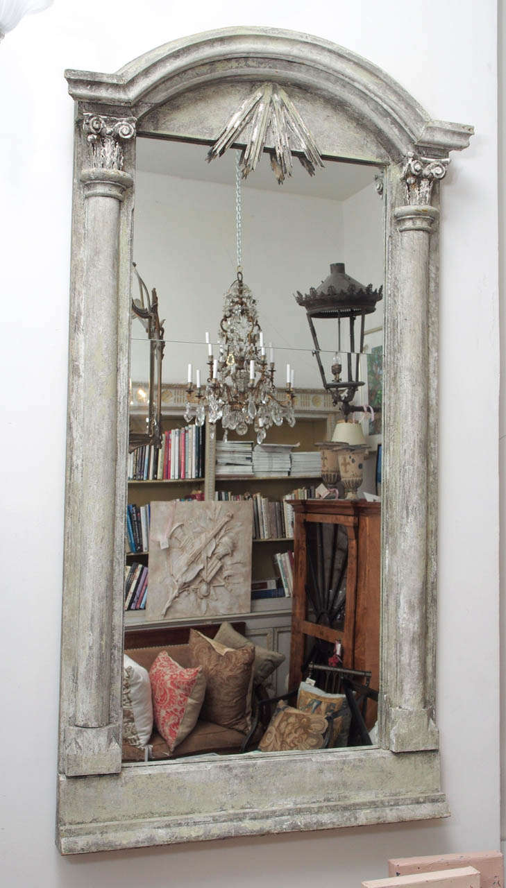 Elegant painted wood mirror with Ionic capitals at the top corners.