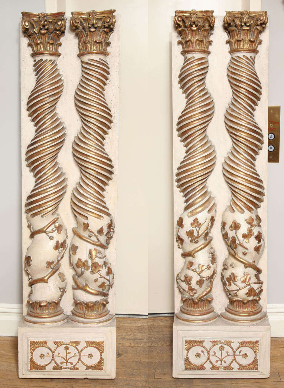 A pair of hand-carved solominic half columns, constructed of walnut, the spiral turned body in the manner of Bernini, restored and gilt and painted finish.