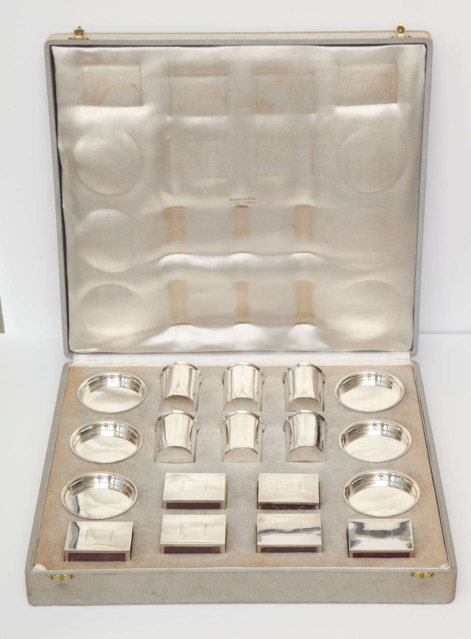 Hermes sterling silver smoking suite in original box.  Rare and fantastic collectors piece consisting of six matchbox holders, six ashtrays and six cigarette pots.  Circa 1960.