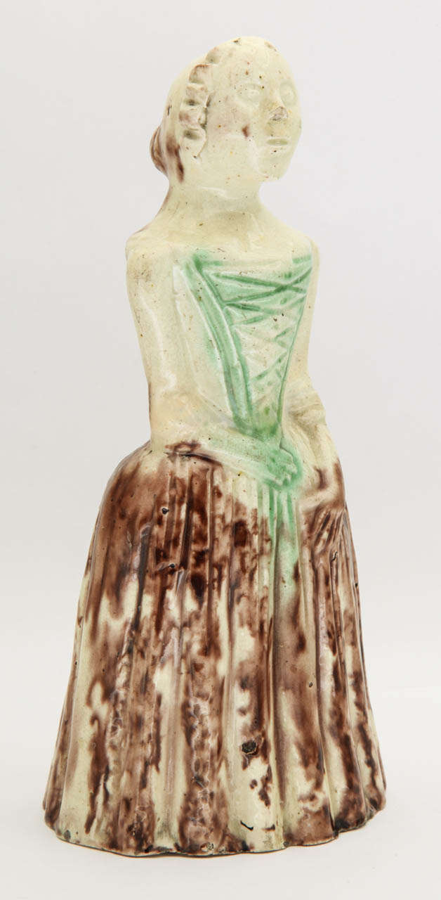 A rare English creamware pottery (Whieldon school) figure of a standing lady decorated in underglaze oxide colors