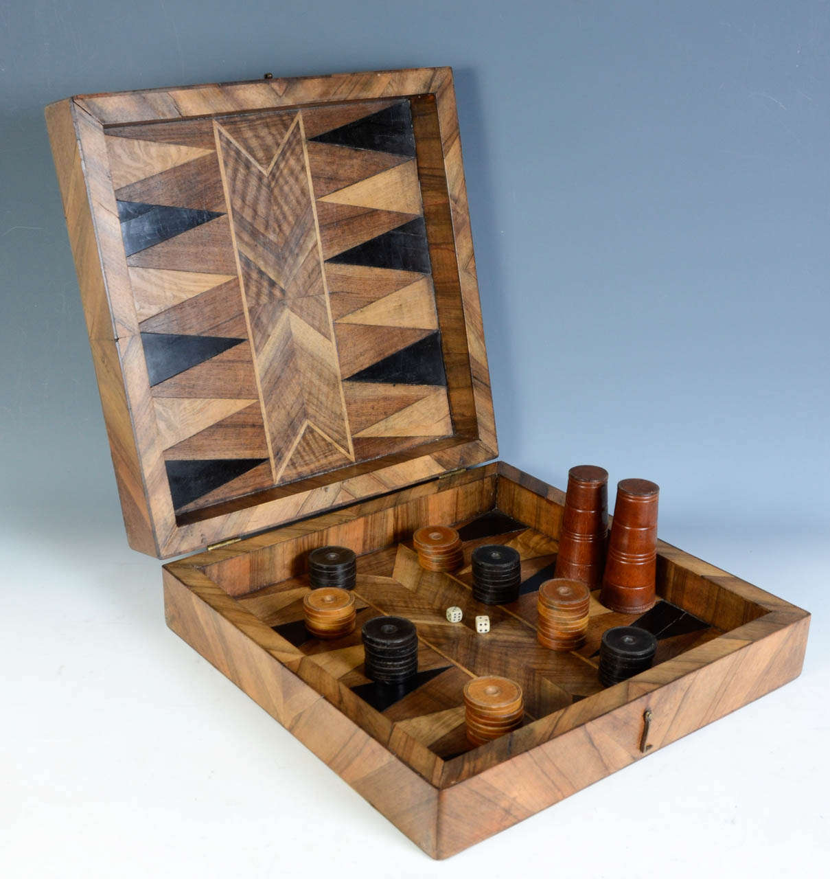 A French Chess Game, a Mill Board Game and a Backgammon Interior.
With 30 backgammon pawns, 2 dices with 2 cups.
French, Walnut, Ebony, Maple, Olive wood, 18th century