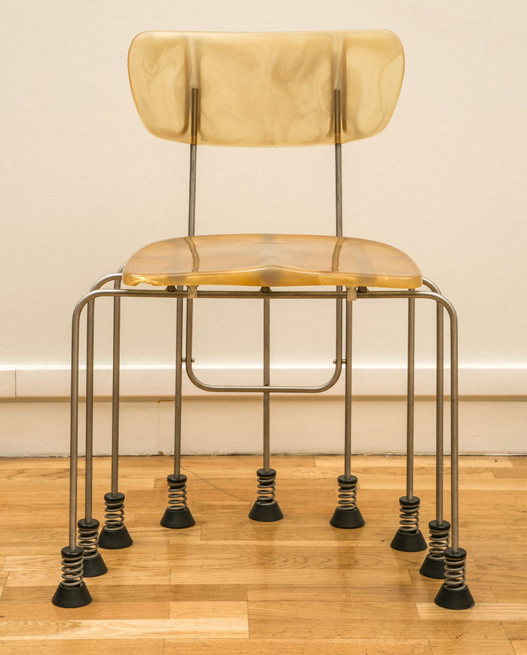 Broadway chair with nine feet by Gaetano Pesce, edited by Bernini.

Stainless steel studs on springs, seat and back in translucent resin with marble  effect. The resin mixture used by the manufacturer craftsman makes each chair a unique model.