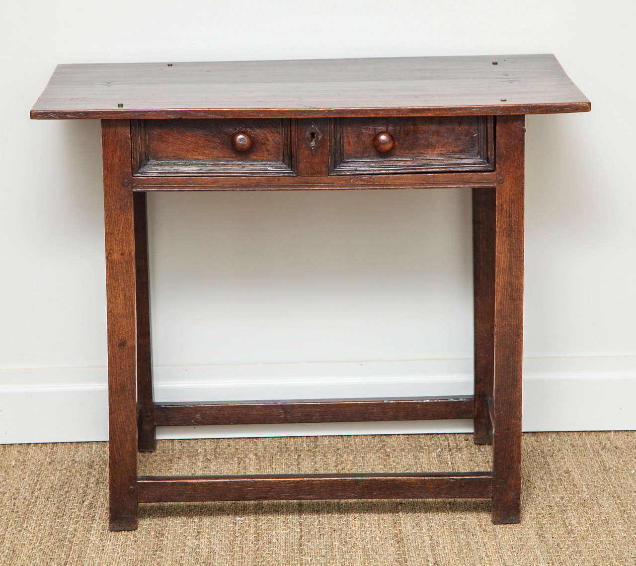 Late 17th or early 18th century English or Welsh oak side table, the two-plank top over single drawer with geometric moldings and original turned yewwood knobs, over simple legs joined by box stretcher, the drawer having original dividers. The