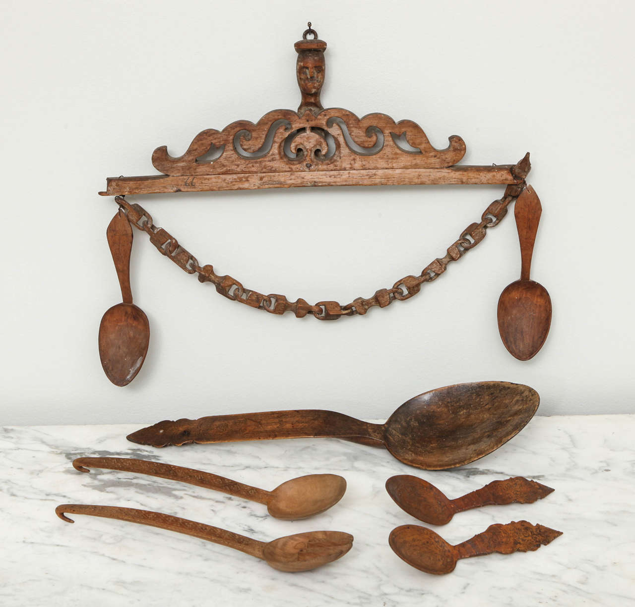 Remarkable collection of Norwegian Folk Art treen spoons, comprising a pair of carved and engraved birchwood spoons with chain on original rack, signed and dated 
