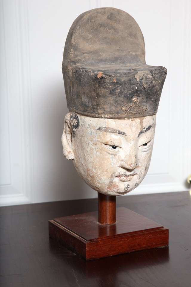 A Ming dynasty well modeled Stucco head sculpture of a Chinese official with original painted details from the 15th-16th century mounted in a custom wooden base. The face showcases gorgeous details carved with a great finesse, which make it look