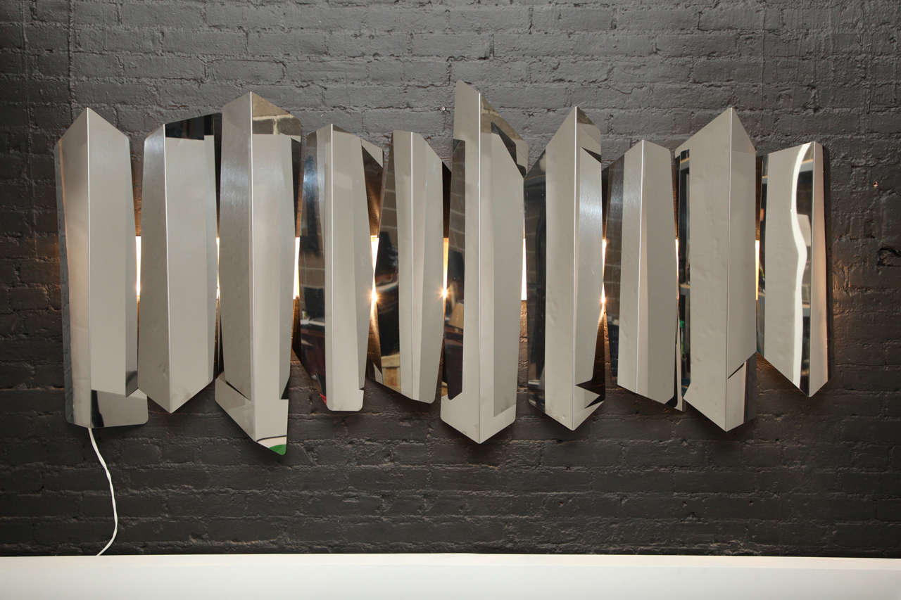 An illuminated wall sculpture in steel by Mario Torregiani

