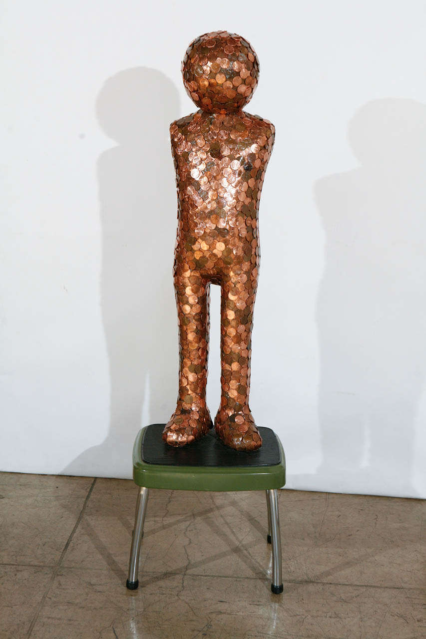 A wonderful androgynous sculpture covered in pennies and mounted on a metal/rubber step stool. Measurement provided are with the step stool. Pennies sculpture alone measure 8