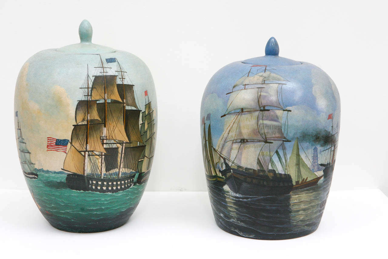 Two hand painted vases with lids of similar dimensions and shape, which could be used as a pair, but are not identical.  Porcelain, made and painted in China with nautical, sea faring scenes of American Tall ships, some under sail, with flags,