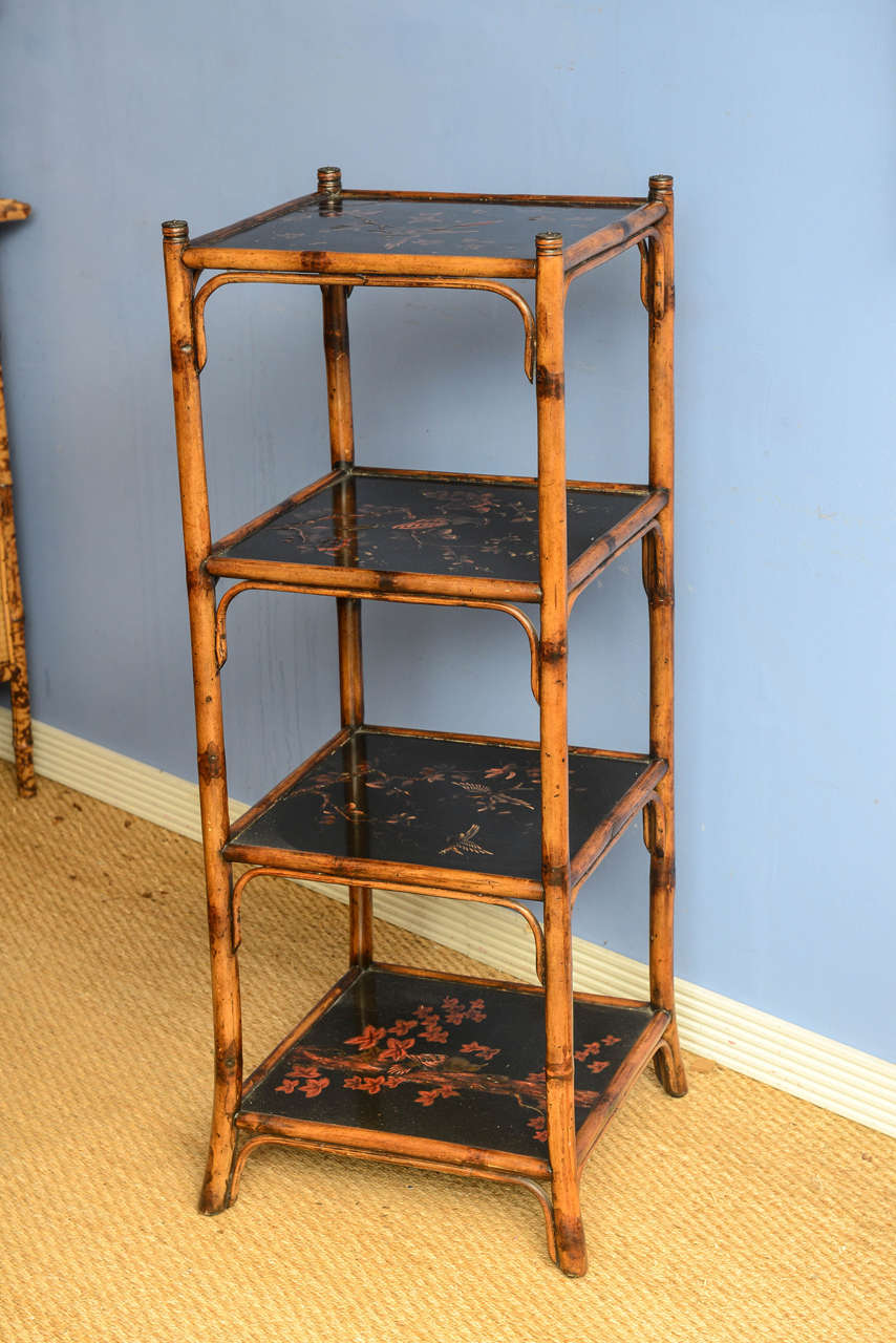 19th c. Bamboo Tiered Stand, fitted with four shelves, each inset with an ebonized panel featuring floral branch and avian patterns, joined by bamboo supports ending in splayed feet, h. 43-1/4