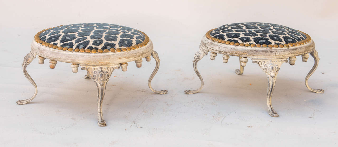 Pair of round footstools, upholstered in leopard print fabric, with nailheads, in wood frame, raised on unusual iron cabriolet legs.  Manufactured for the J.N. Adam & Co. department store, Buffalo, NY, circa 1930s.

Stock ID: D6488