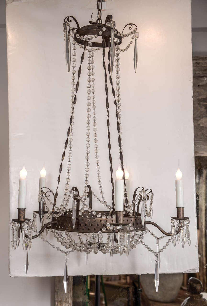 Tôle and crystal chandelier, early 19th century pierced tole and iron chandelier frame. Decorated with recent chains of glass beads and crystal prism pendants. Five-lights (candelabra size) newly wired for use within the USA using all UL approved