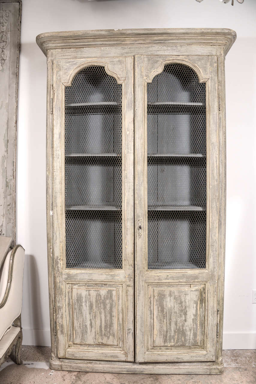 Pair of painted Italian 19th century bibliothèques with chicken wire panels and shaped interior shelves.