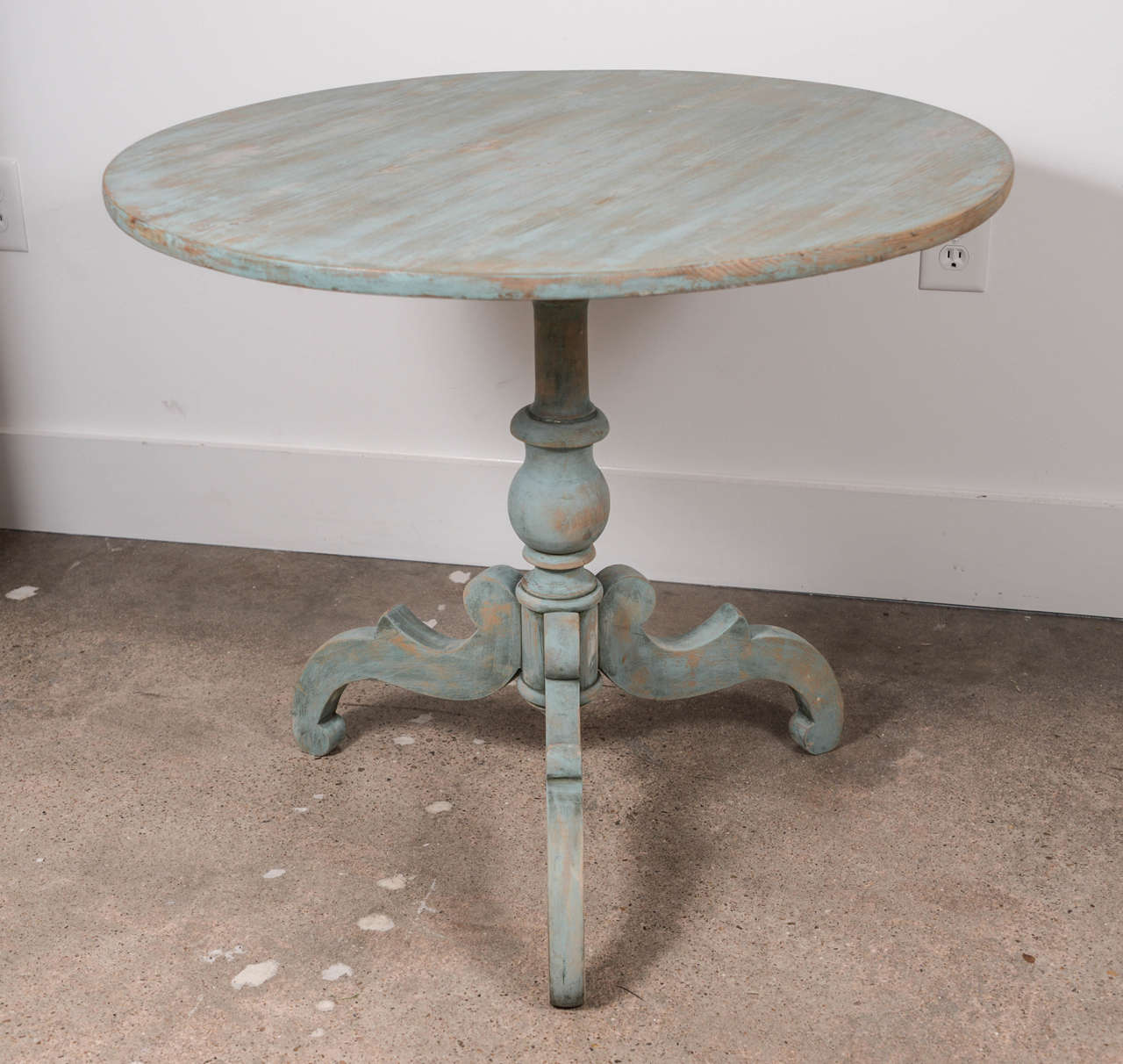 Decorative blue painted 19th century tilt-top pedestal table with a turned base supported by 3 scrolled feet.