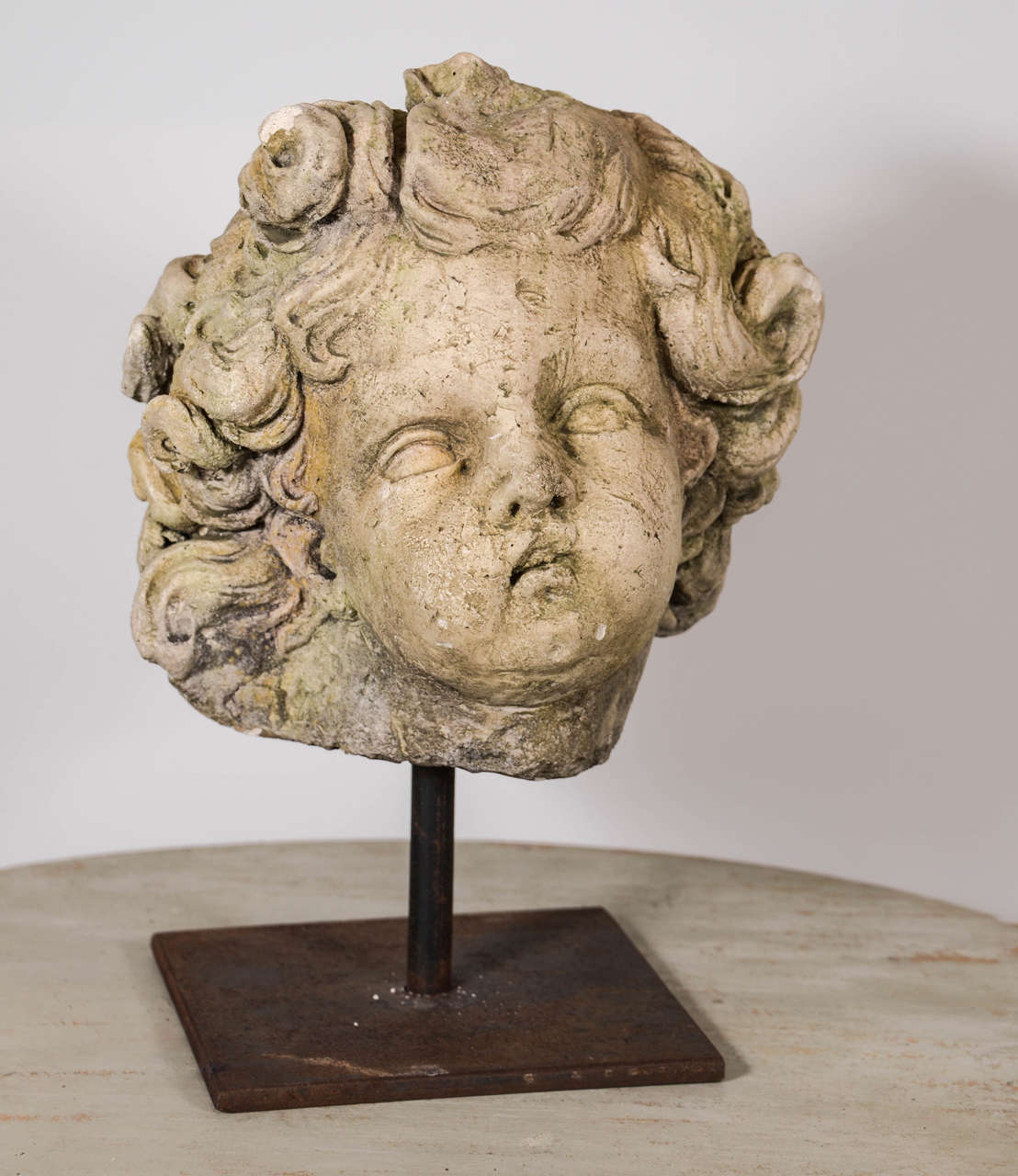 19th century casting of cherub bust mounted on stand.