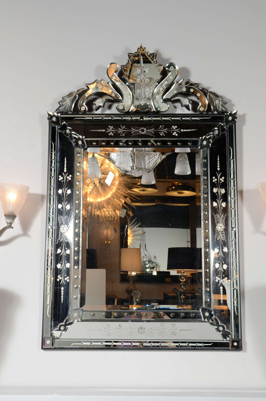 Elegant, reverse etched and beveled Venetian mirror. Reverse etched convex and floral detailing on the border and upper cartouche.