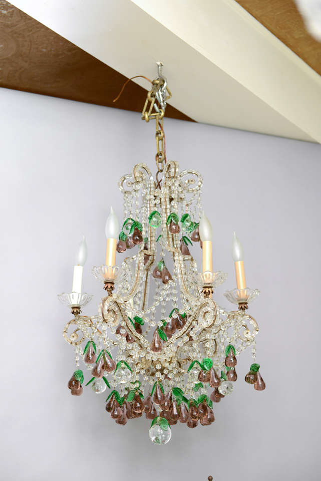 Chandelier, in the Italian Maria Theresa style, having a cage-form frame of gilded iron, entirely affixed with cylindrical beads, six scrolling arms holding scalloped bobeches and candles; the entire fixture strung with stands of round glass beads,