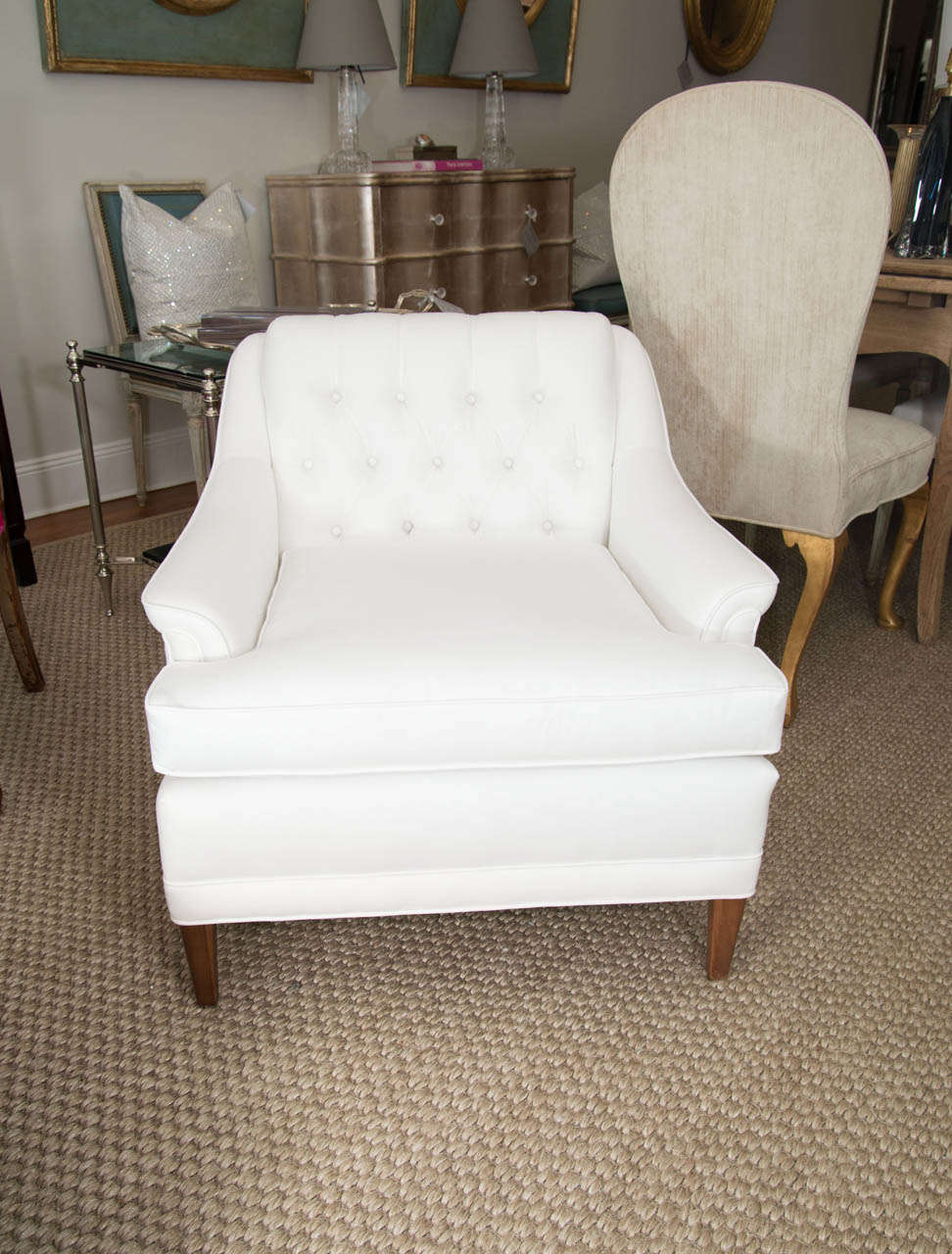 A very chic pair of upholstered arm chairs with tufted backs.
