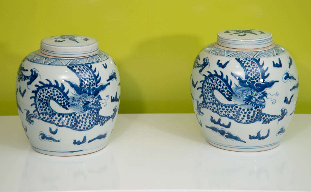 A pair of Chinese porcelain jars depicting a dragon motif.  Dating from the early 20th century, these jars have an appealing shape and beautiful color.
