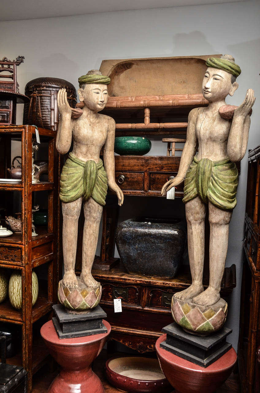 Pair of late 19th century Burmese lacquered temple statues used to support a gong between them face to face.