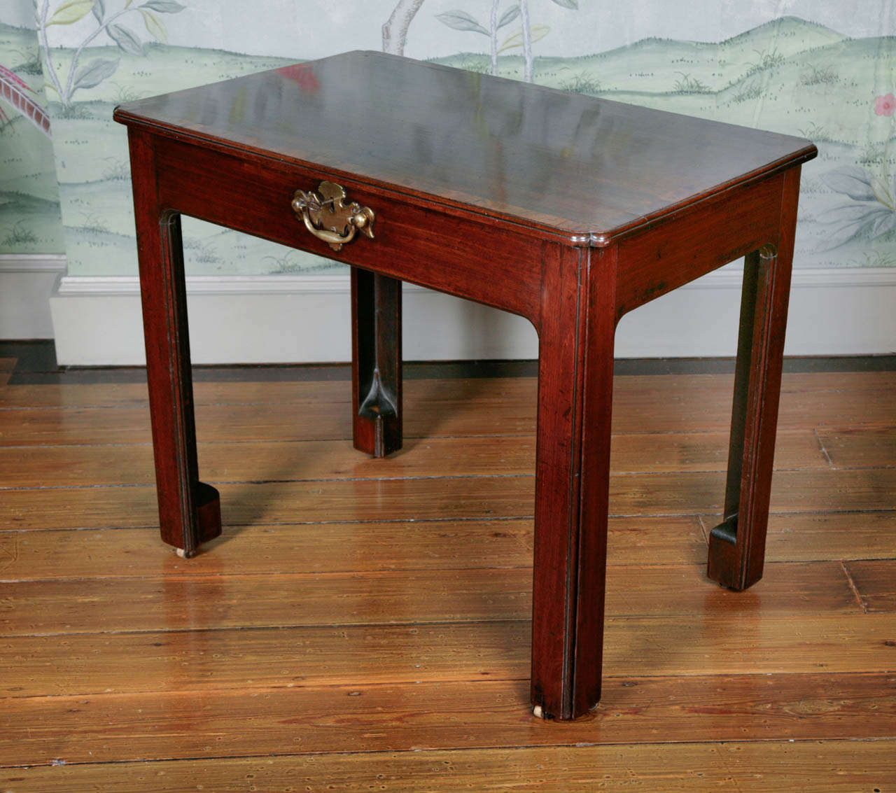 This table dates from circa 1750 and has a wonderful deep and rich patina. The top has carved re-entrant corners and the front of the table can pull out to form a writing surface which is covered in a green baize which can slide backwards to reveal