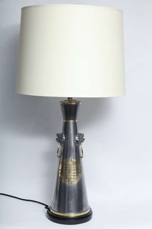 A pair of Modernist form table lamps, produced circa 1950s, crafted of pewter with brass banding and Asian motifs, mounted on black lacquered base.
New sockets and rewired
Shades not included