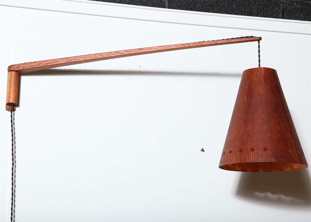 60's solid Teak swing arm, wall mounted lamp with cone shaped shade. Adjusts laterally and vertically. Extends up to 36