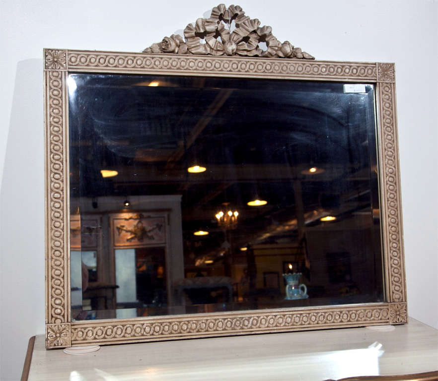 Attractive French rectangular mirror with annulated and patera-carved frame, surmounted by a ribbon and flowerhead crest.