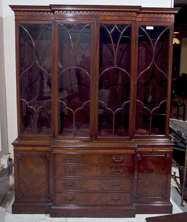 Georgian style mahogany breakfront, circa 1950s, the beautiful dentil molding(all intact) over a conforming glass-front cabinet, atop a flame mahogany base with graduating drawers and pull-out slides.  <br />
<br />
Stamped S&K Schmieg & Kotzian