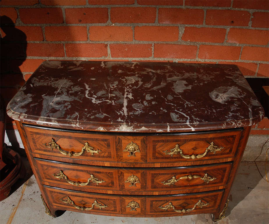 French Regency doré bronze ormolu and kingwood marquetry commode with marble top.