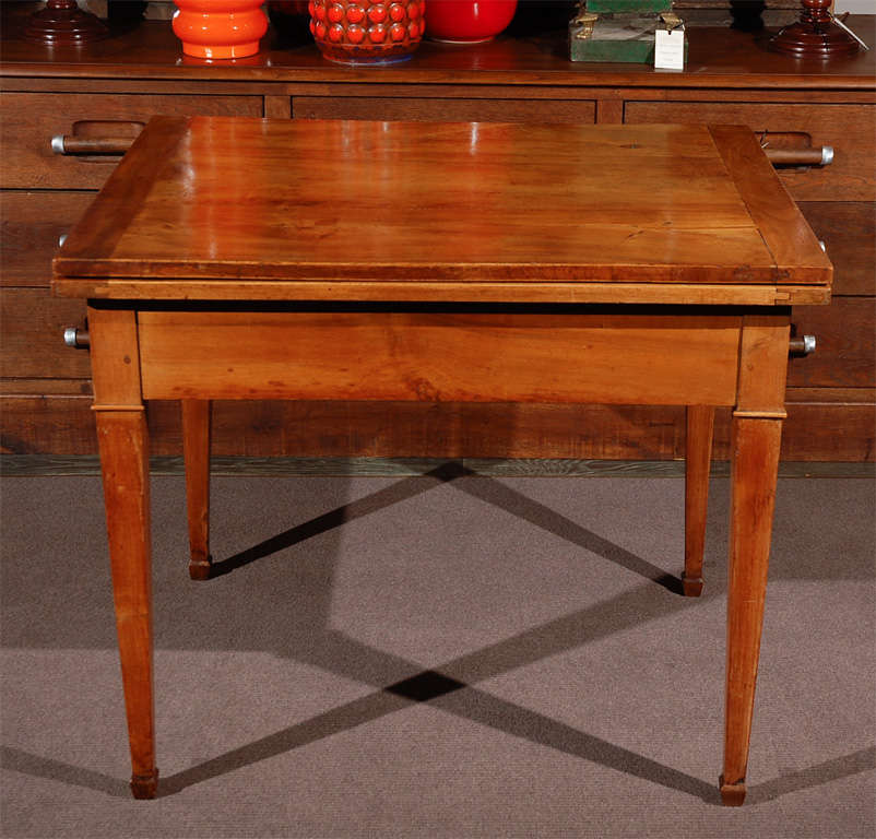 1860s French rectangular cherrywood extension table. Rectangular top dining table on tapered legs with spade feet. The table extends to 63