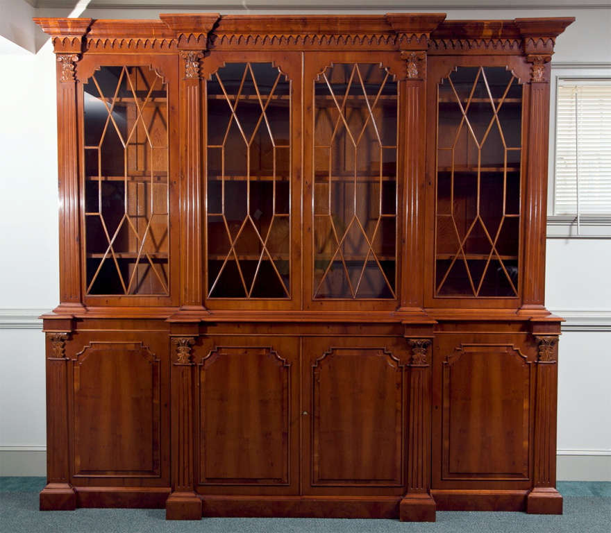 Custom made for us in England by talented craftsmen, this classically styled Georgian breakfront with columnar accents has a presence that is unmatched by many of today's bookcases and display cabinets. The rich, honey tone of yew wood affords this