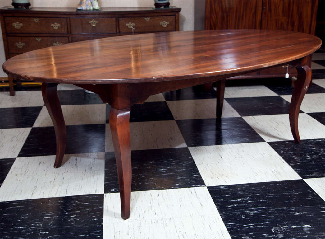 The gentle elliptical shape of this French style manor house table allows for seating of 8 people comfortably, with the possibility of 12 if four are willing (or can be cajoled) to straddle a leg.  The attractive curves of the cabriole legs