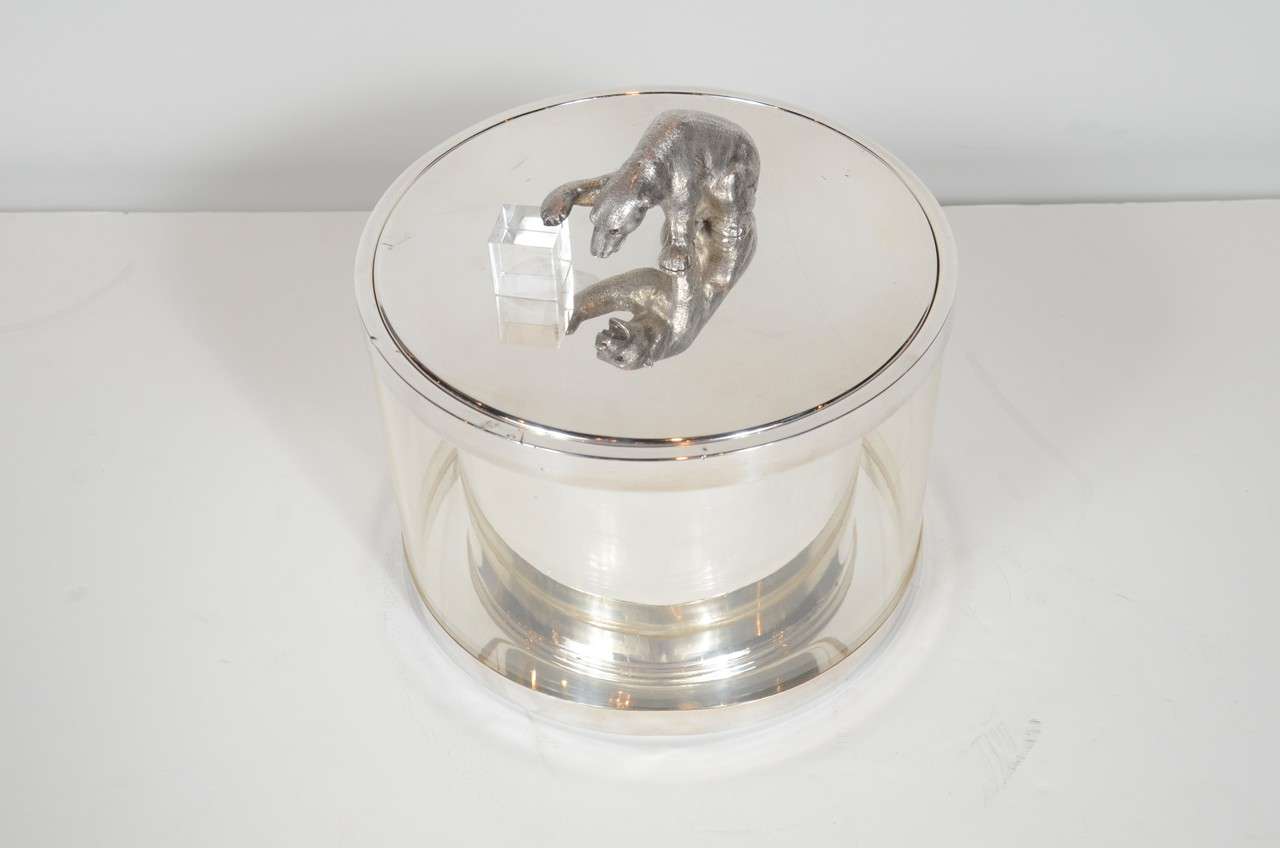 This super chic Mid-Century Modernist ice bucket / wine cooler has a Lucite outer case and silver plated interior, lid and base. The lid features a figure of a polar bear holding an Lucite ice cube as a handle. It is in fine vintage condition.