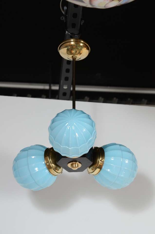 This unique Art Deco chandelier has three fluted pale blue globes with brass fittings and ebonized walnut . Completely re-wired and in excellent condition.