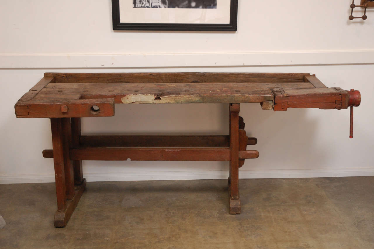 An interesting and well used craftsman's work bench from circa1900, having a vice and other elements. The bench has lots of character from having been used for a considerable period. 

