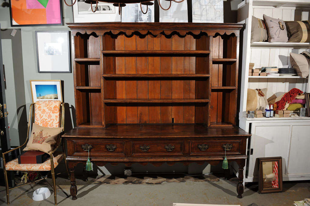 Carved wood Welsh Hutch with wonderful scalloped detailing, upper shelves, three drawers and turned and carved legs. With unusual drawer construction for the period, employing the use of nail joinery and a thick veneered facade secured and