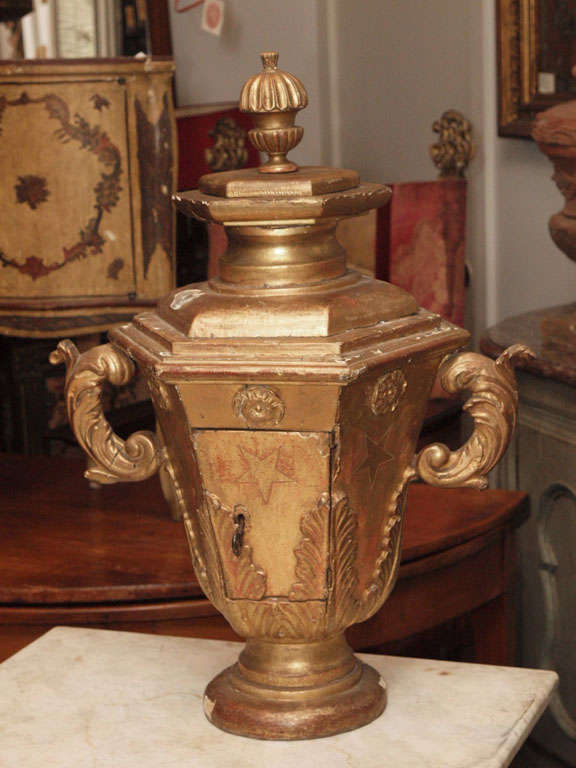 An unusal carved and gilded hexagonal urn form tabernacle, the urn with handles and a pedestal base and including a door revealing a hollow interior.