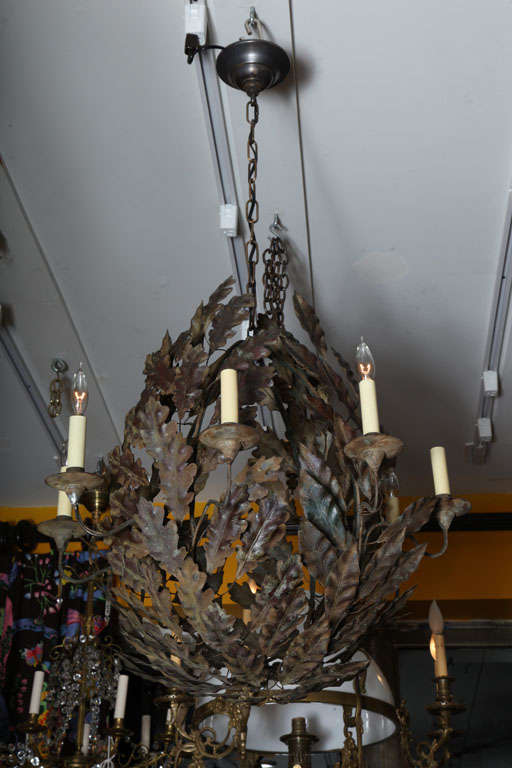 An eight light American painted tole chandelier, the body formed by branches of Sycamore and oak leaves.