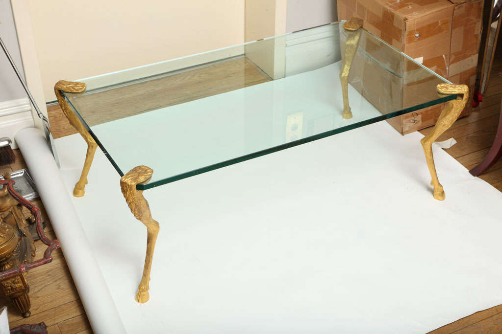A French Louis XVI style rectangular* coffee table with finely chased and gilt cast bronze legs in the form of deer legs with split hooves, the glass top supported by opening secured at top and bottom by table legs. Signed by maker P.F. Guerin New